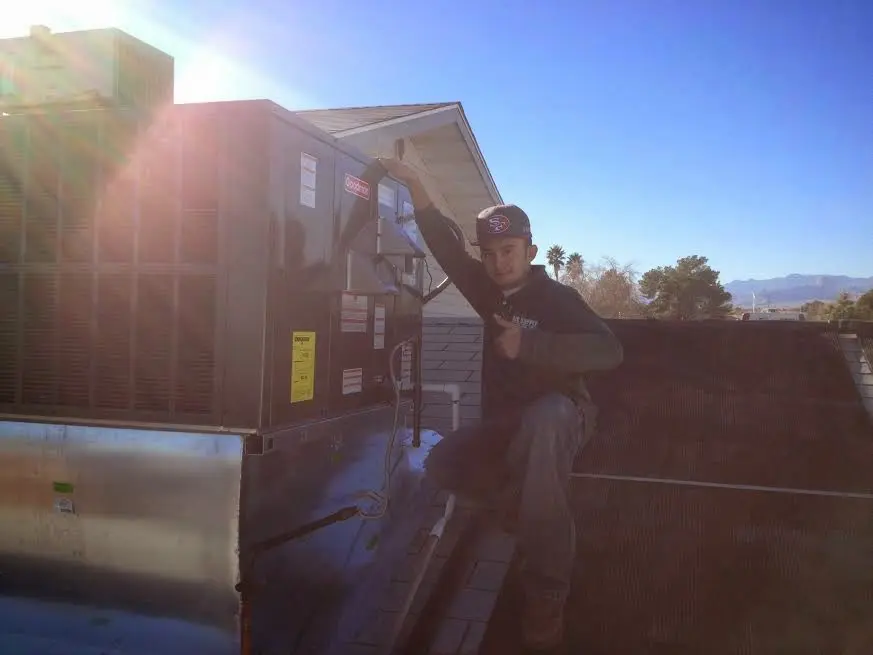 HVAC technician performing HVAC Inspection on a rooftop unit in Stafford